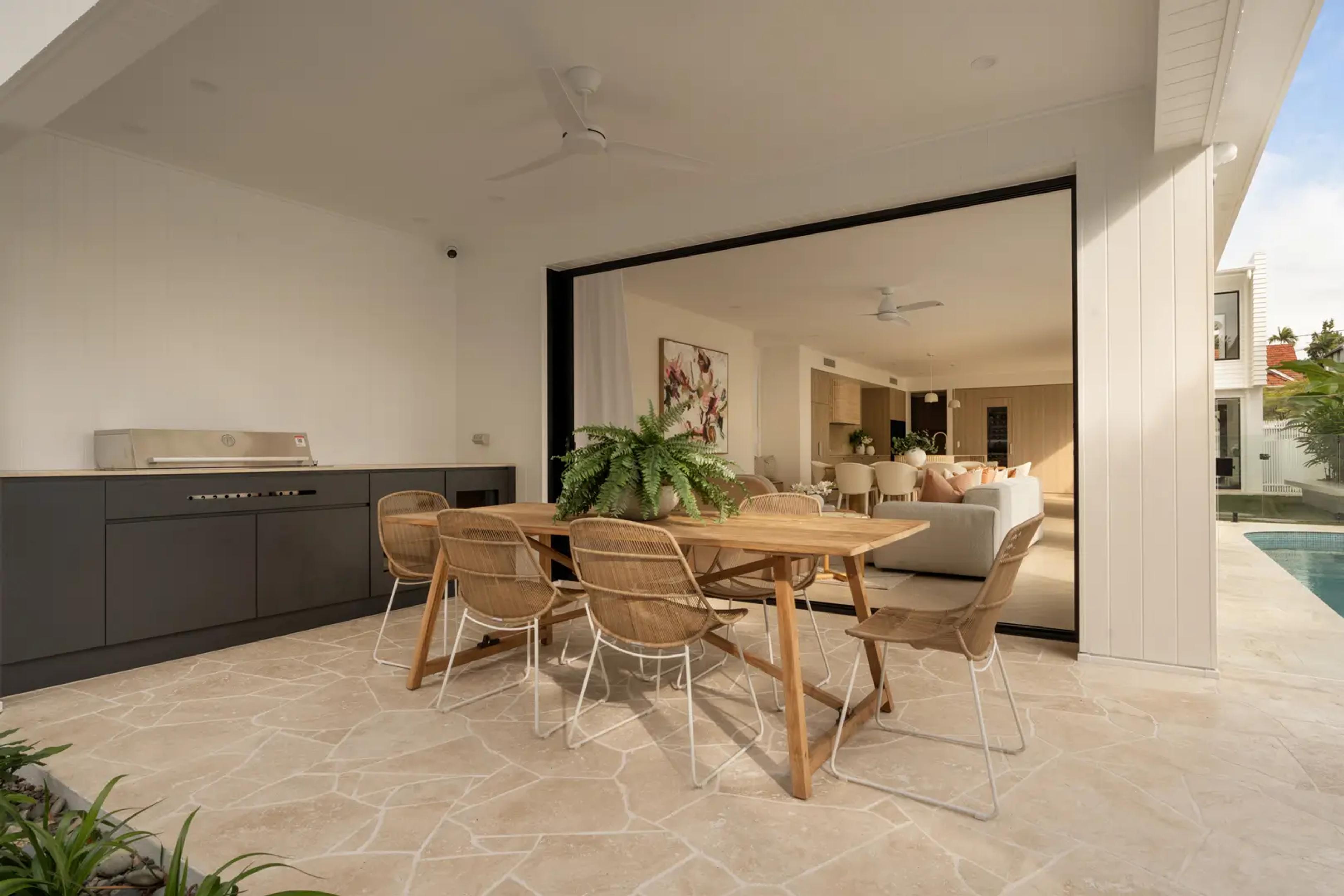Covered outdoor kitchen and dining area beside pool