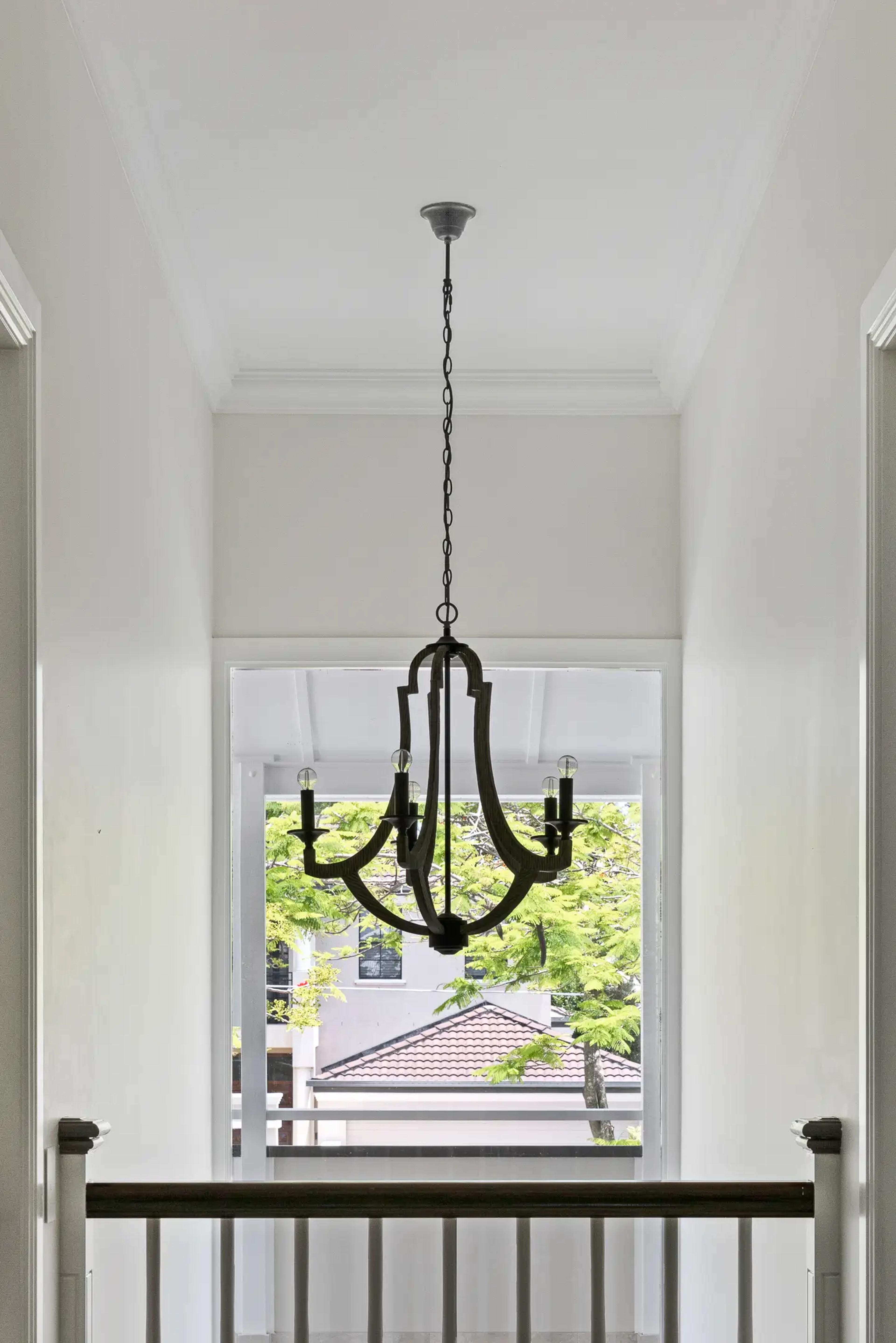Stair landing with chandelier and window to treetops
