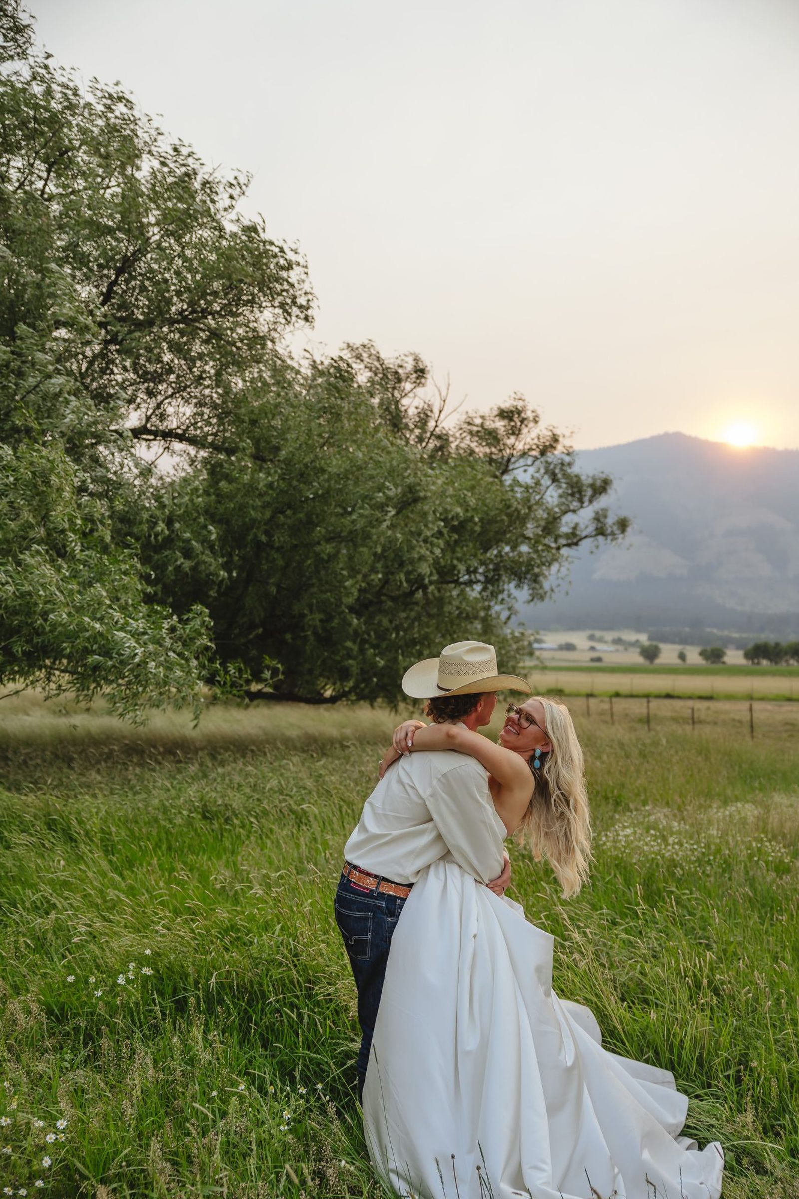 Couple embracing at sunset with the mountains behind