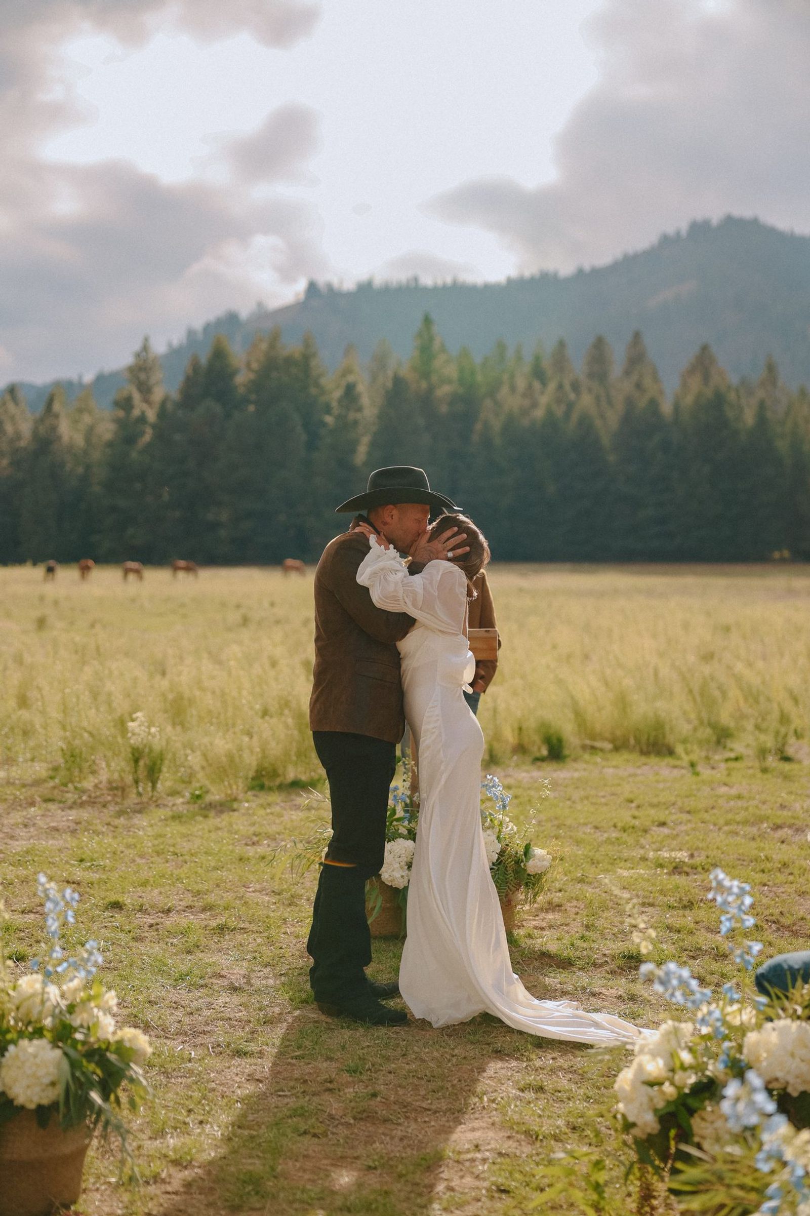 Couple in the wheat field with the mountains behind them