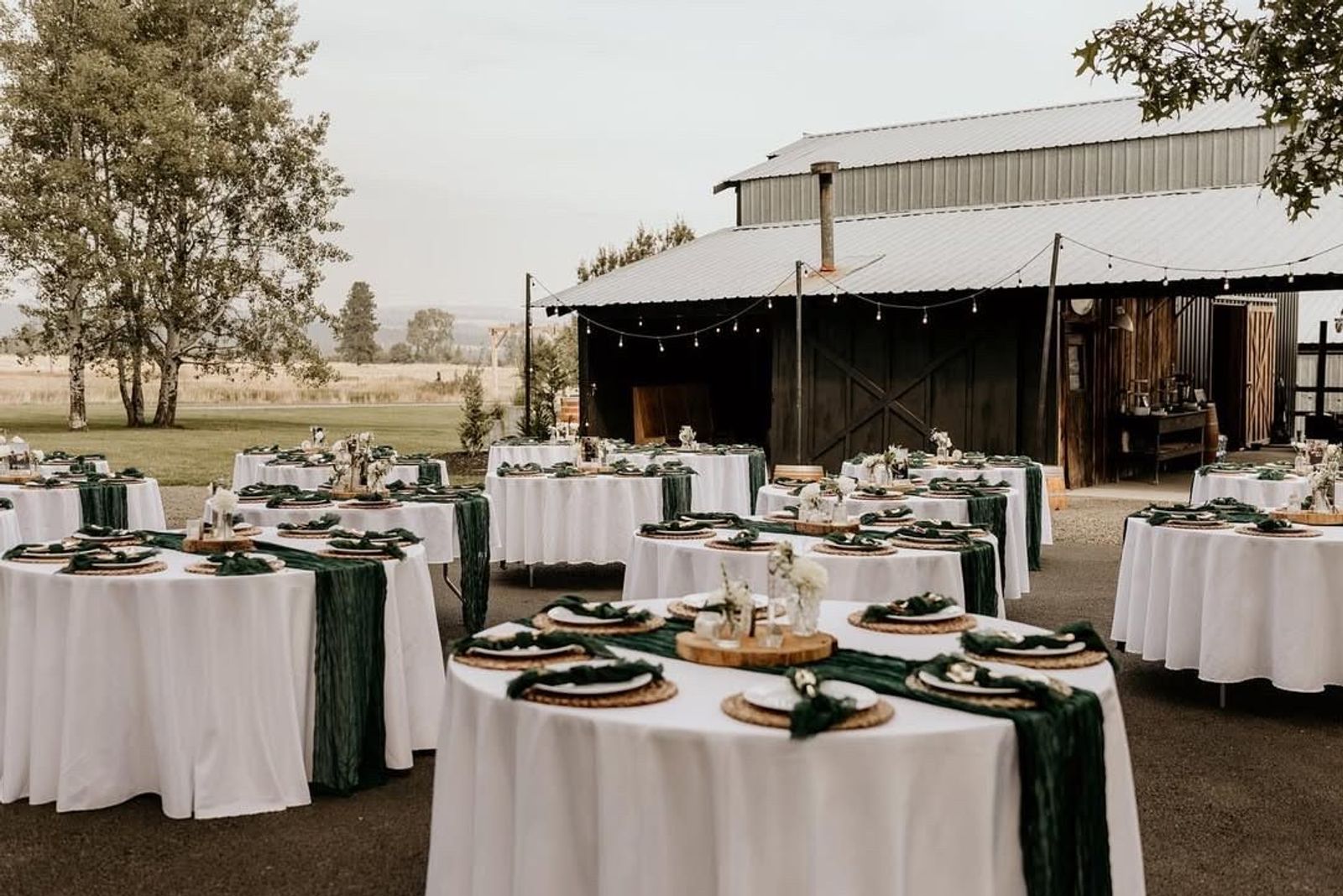 Reception tables set outside the barn at golden hour