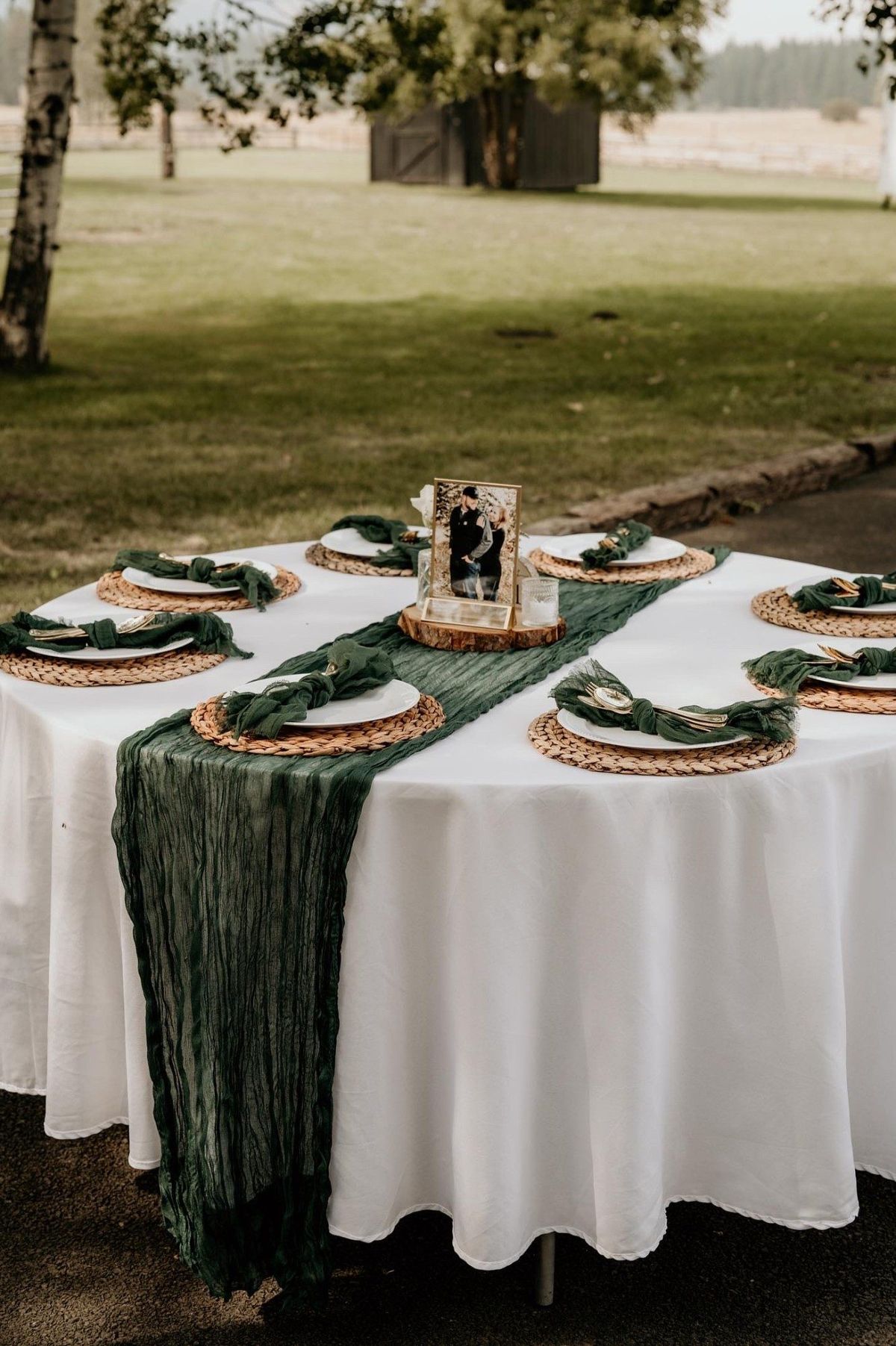 Round table set with green runners and woven chargers