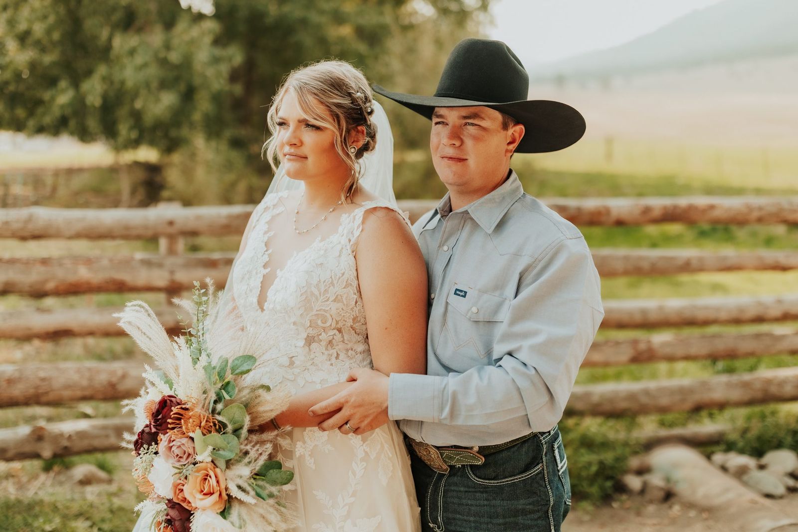 Couple by the fence with her bouquet