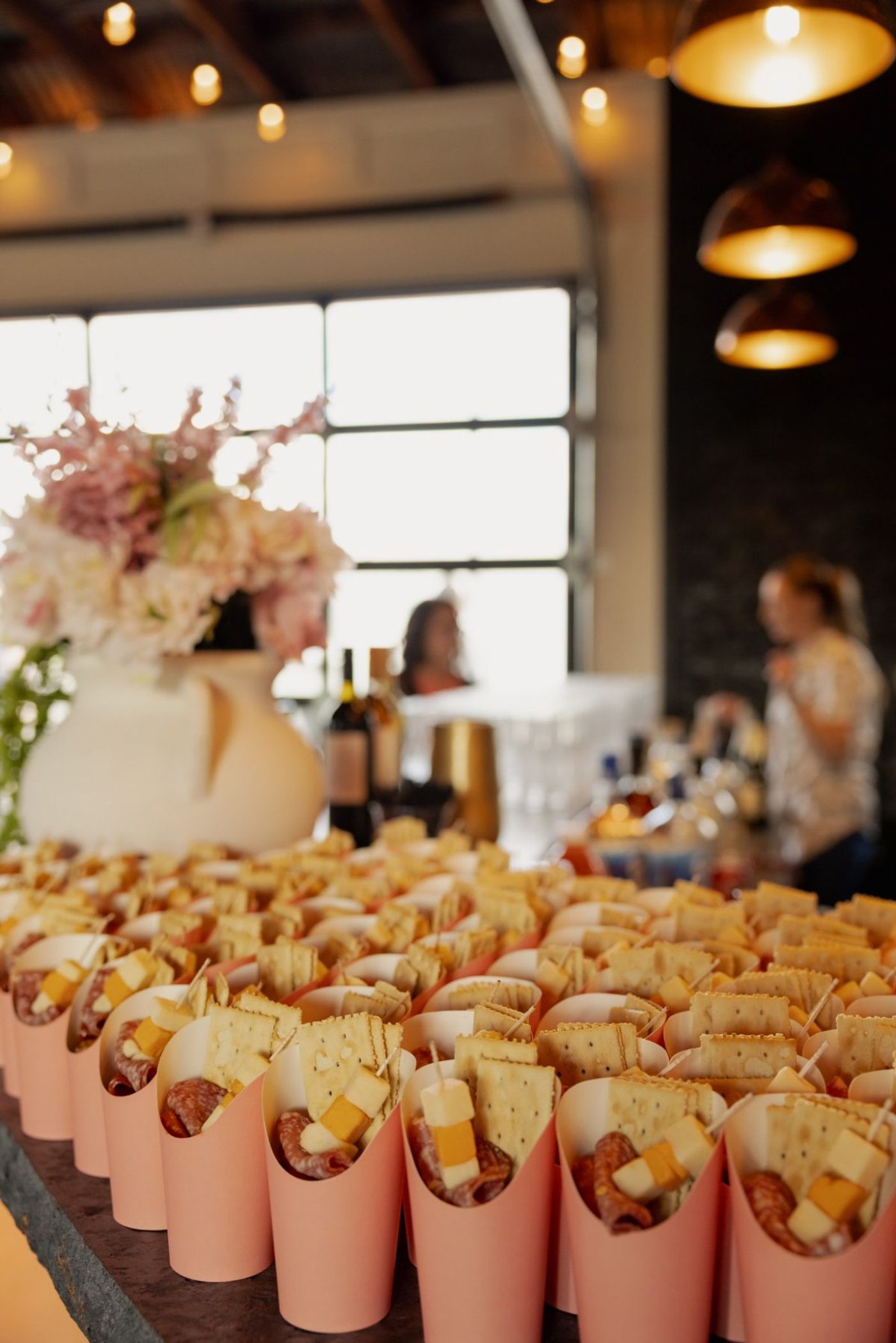 Rows of individual charcuterie cups ready for guests