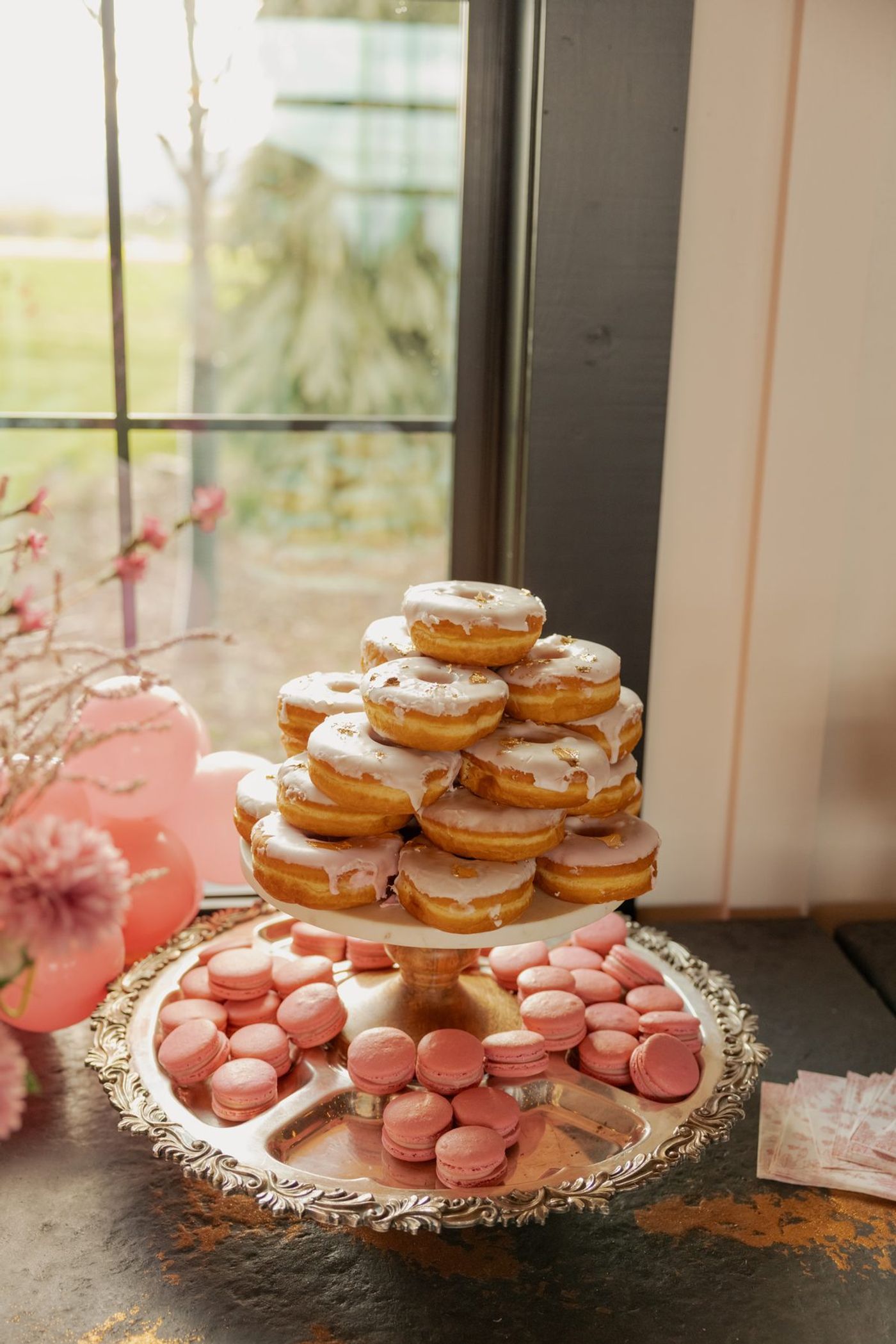 Donuts and pink macarons on a tiered stand