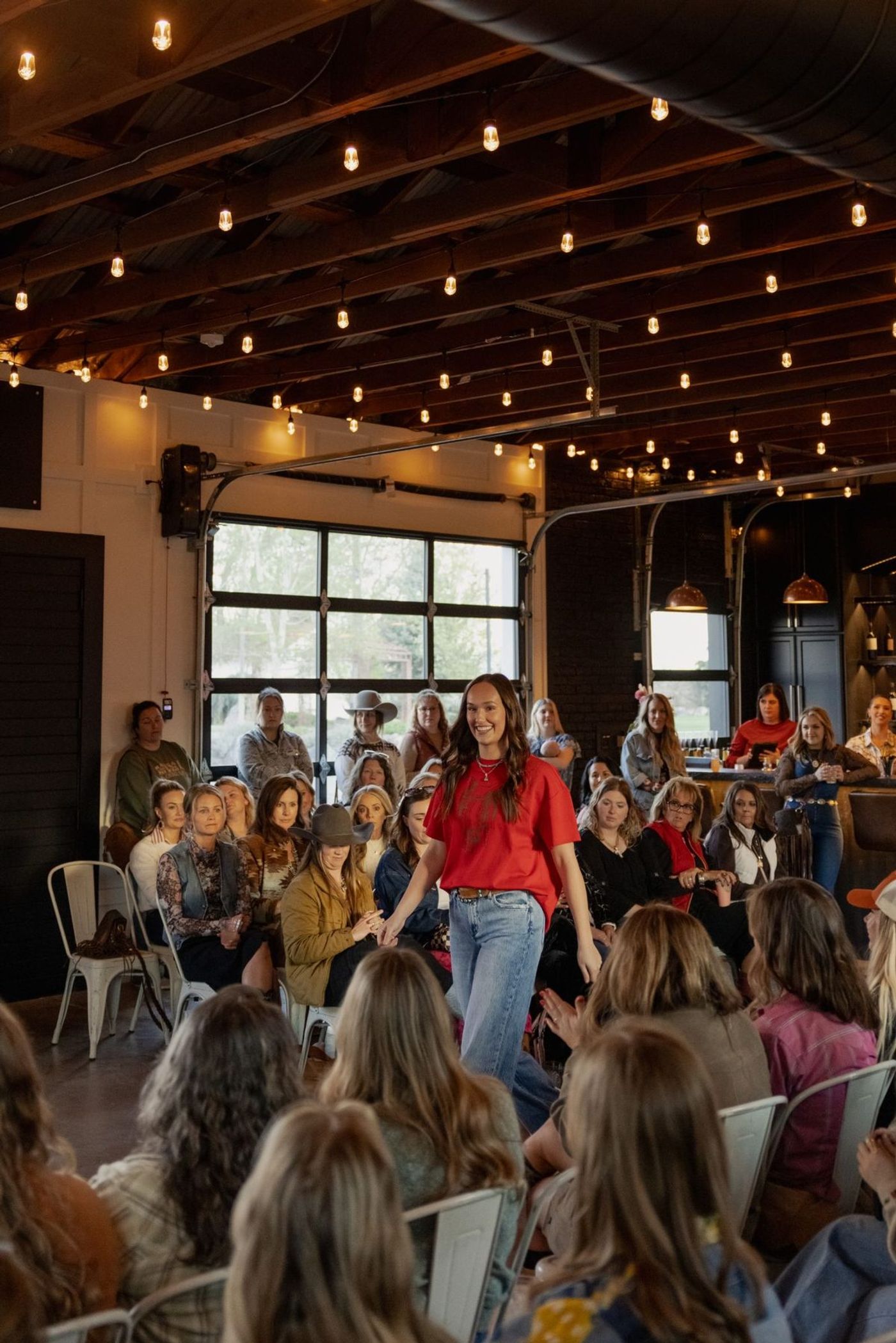 A model walking the runway in a red tee and jeans