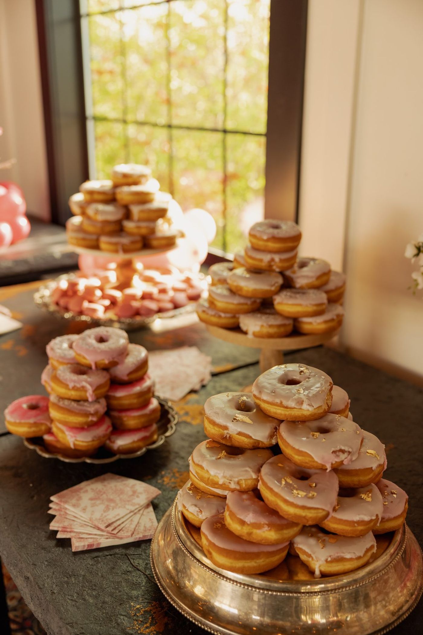Towers of pink frosted donuts on the dessert table