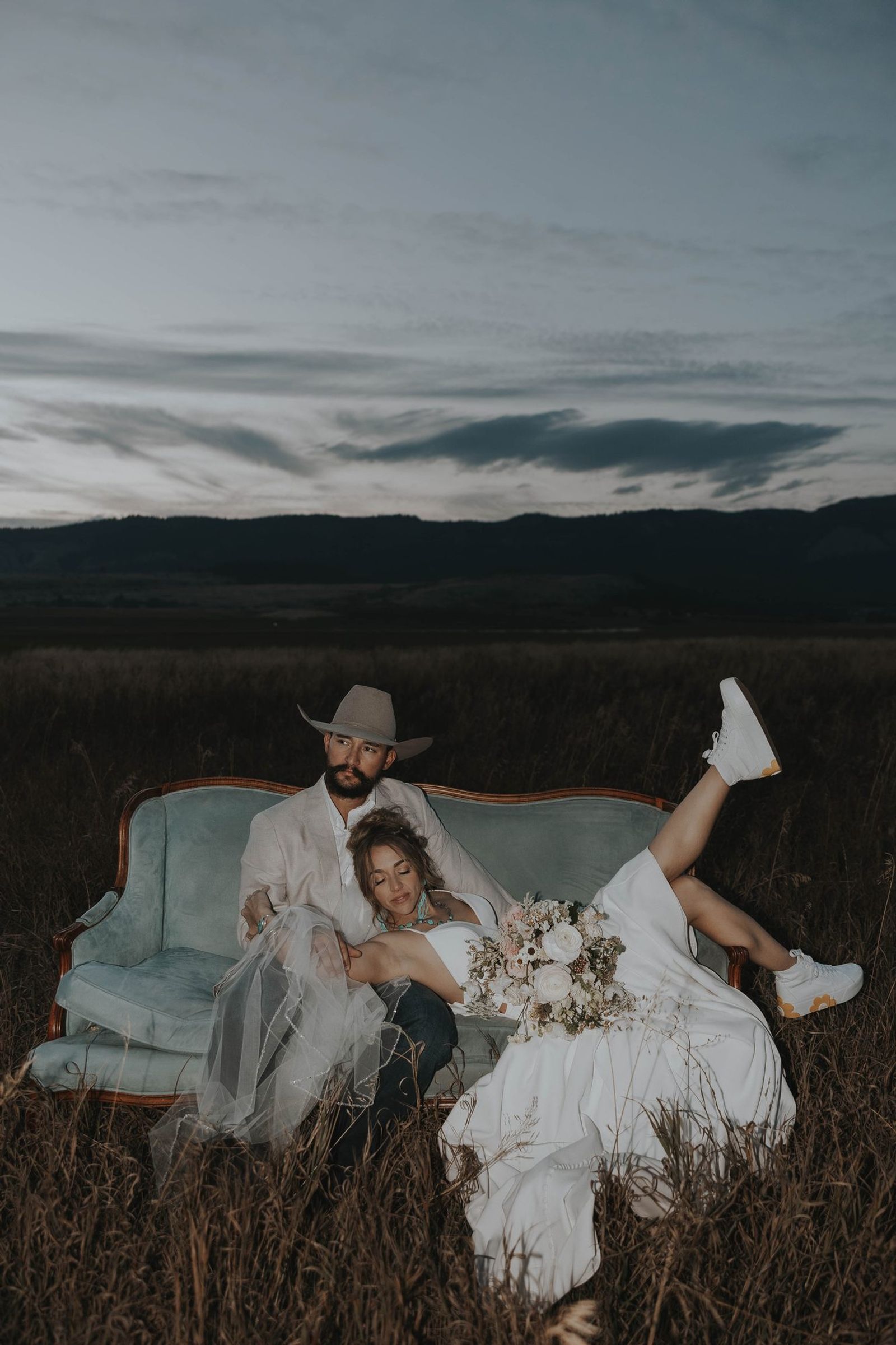 Couple on a vintage couch in an open field