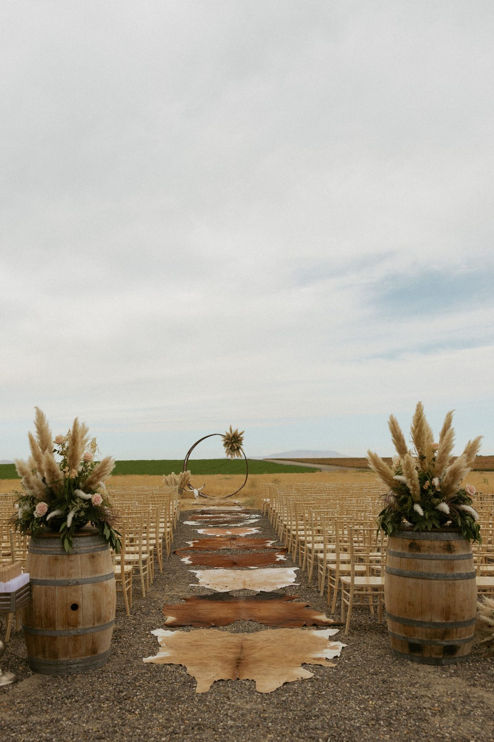 Aisle lined with barrels and florals before the ceremony