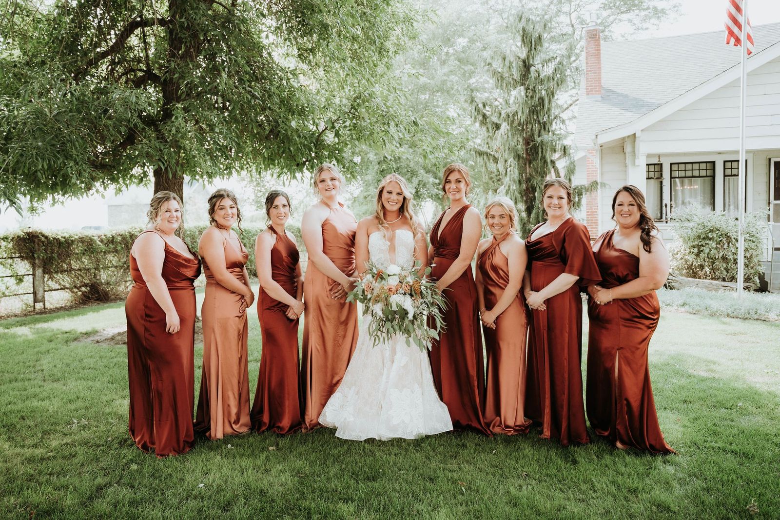 Bride with her bridesmaids in rust dresses