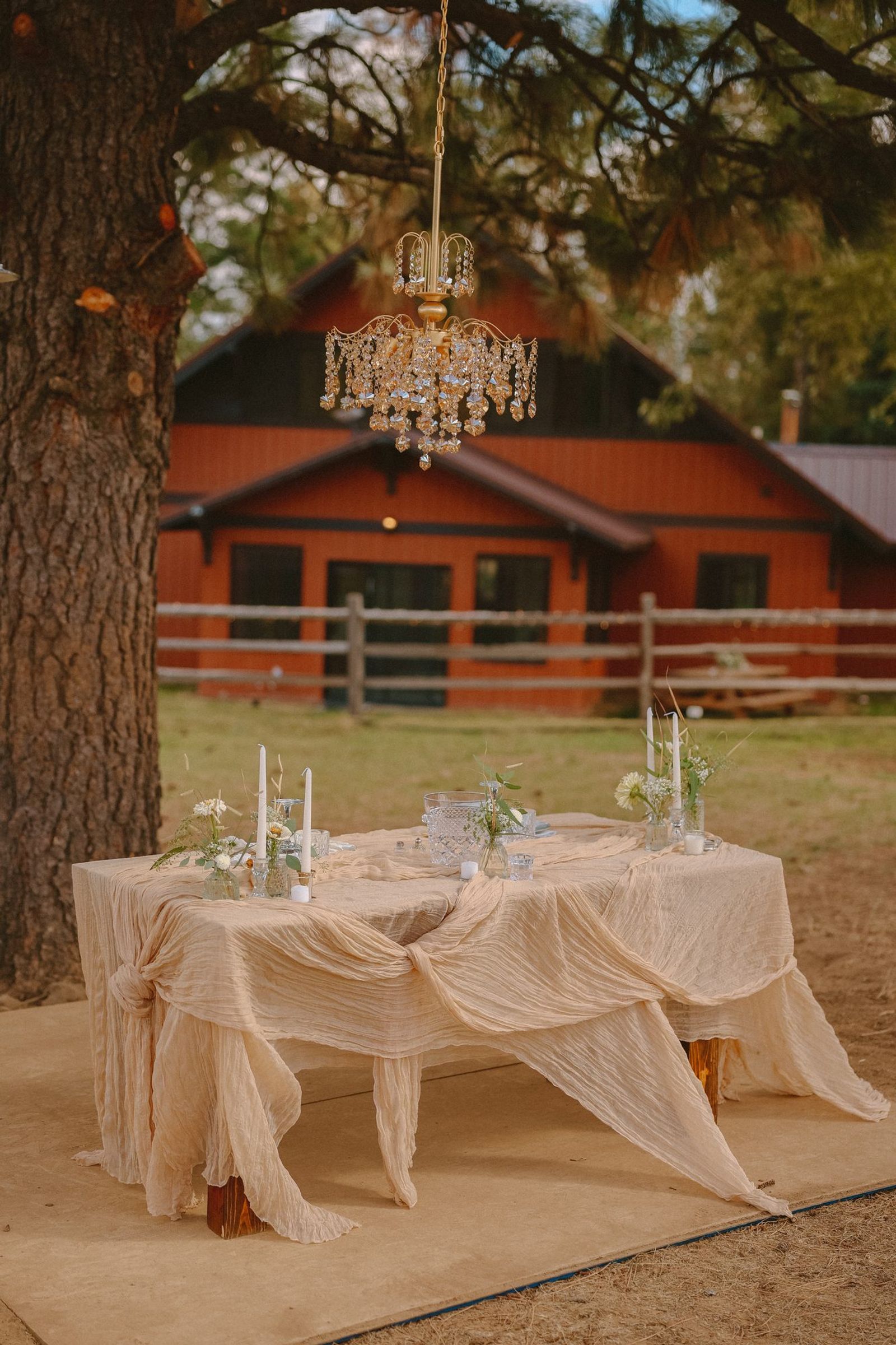 Sweetheart table with a chandelier at the red barn