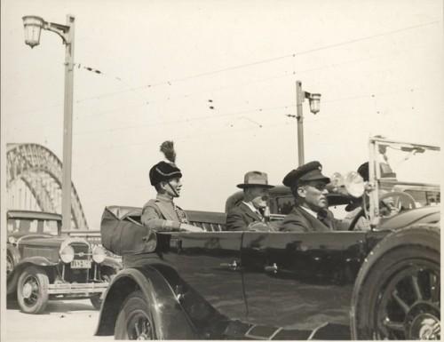 A group of men stand with the Sydney Harbour Bridge in the background