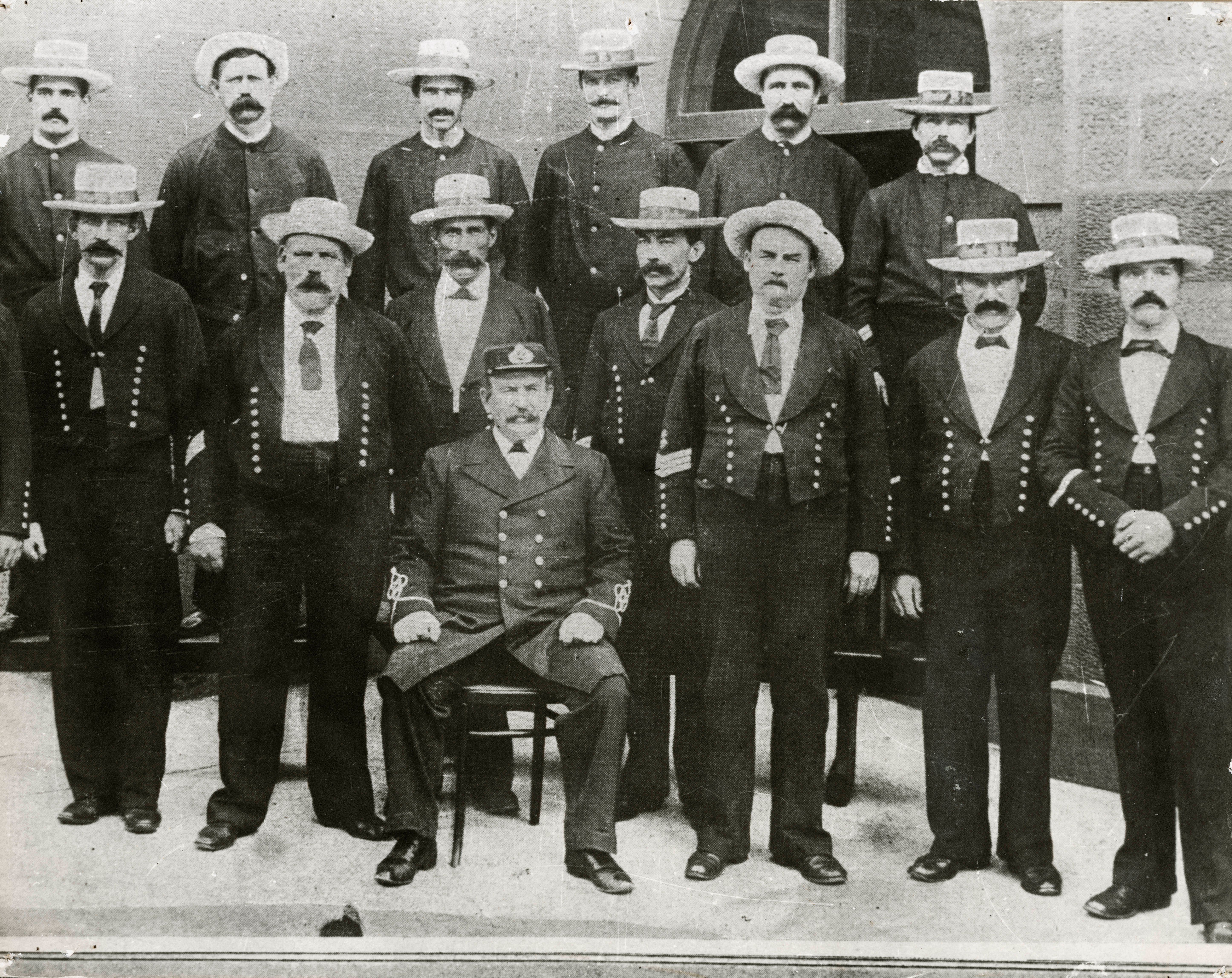 A group of men in uniforms, wearing ties and hats