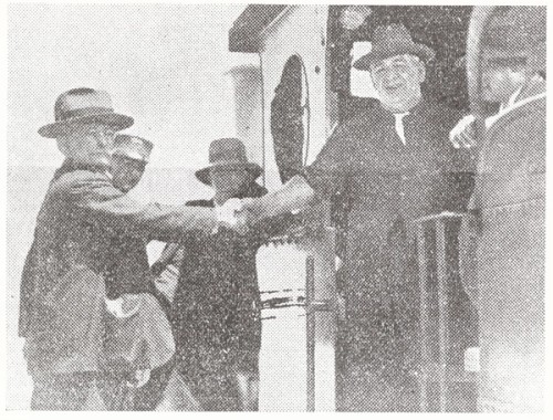 Two men shake hands for the camera