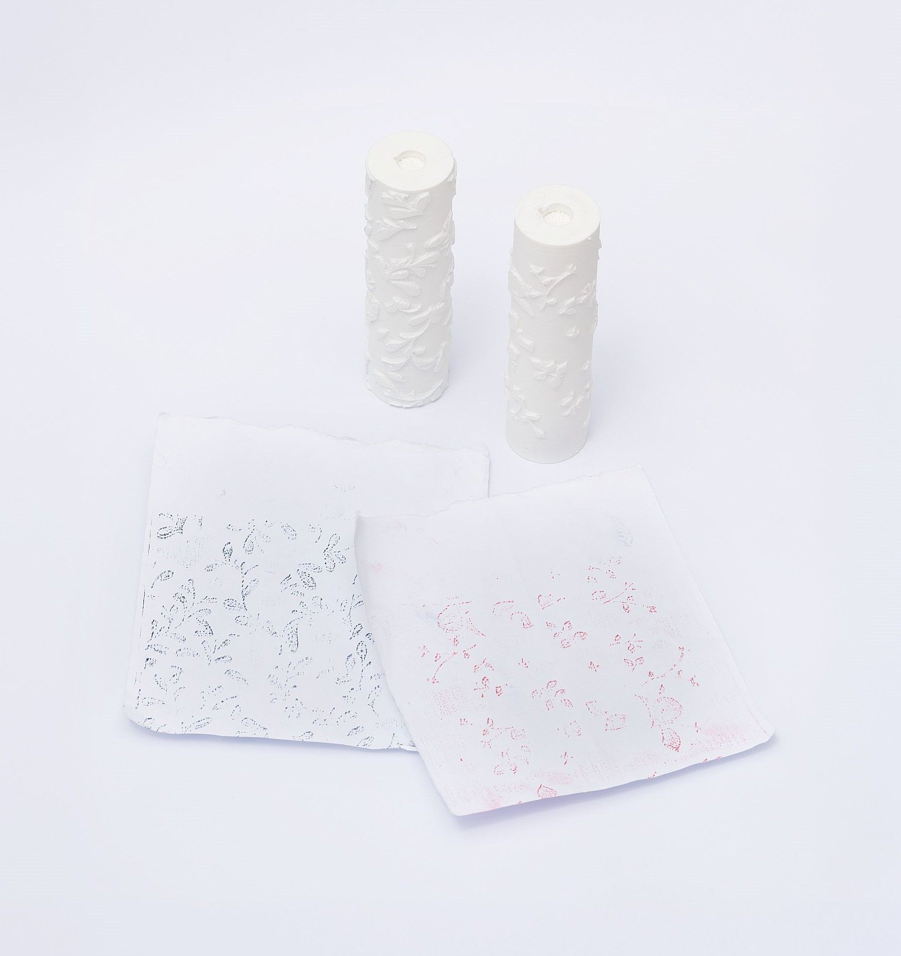 Reduced-size 3D prints of the wallpaper rollers shown with imprints of their designs