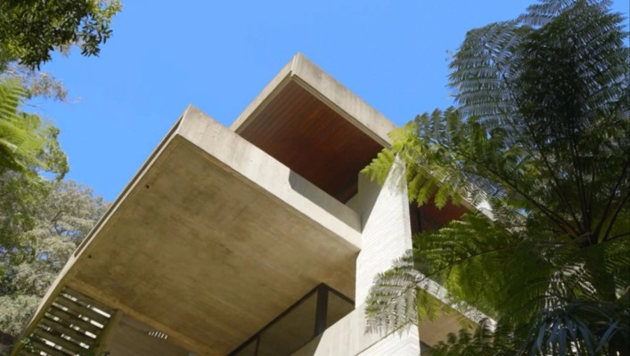 Image looking up at the corner of a concrete building against a blue sky