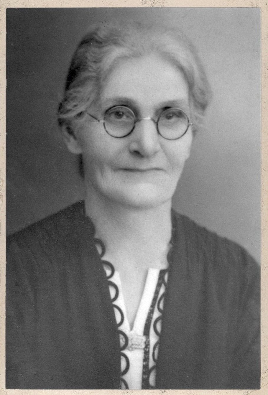 Black and white portrait photo of a women with grey hair and spectacles