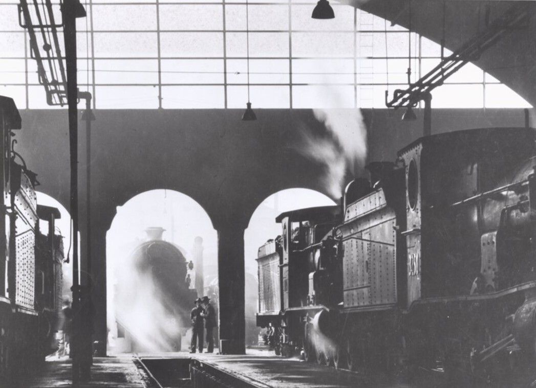 Eveleigh depot showing steam locomotives and two men standing at the entrance