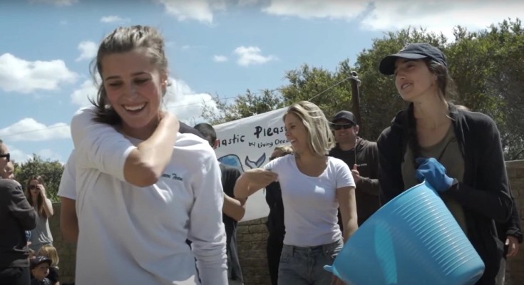 a group of people stand in front of a sign No Plastic Please