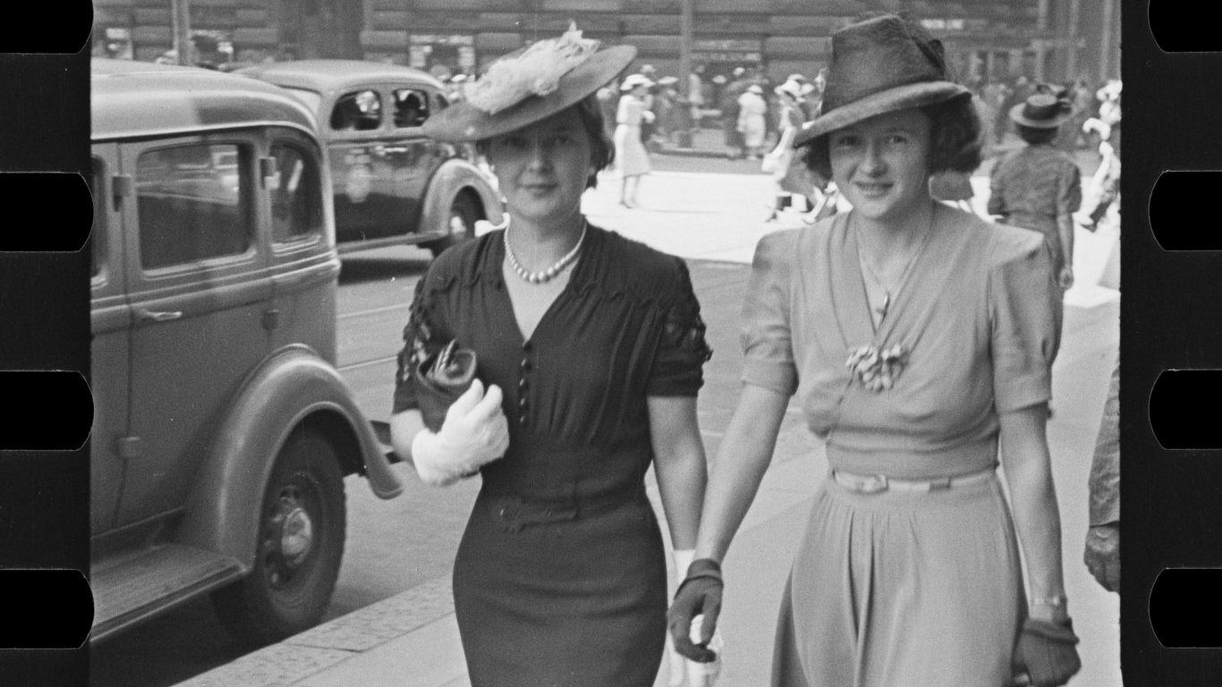 Black and white photo of two women in street.