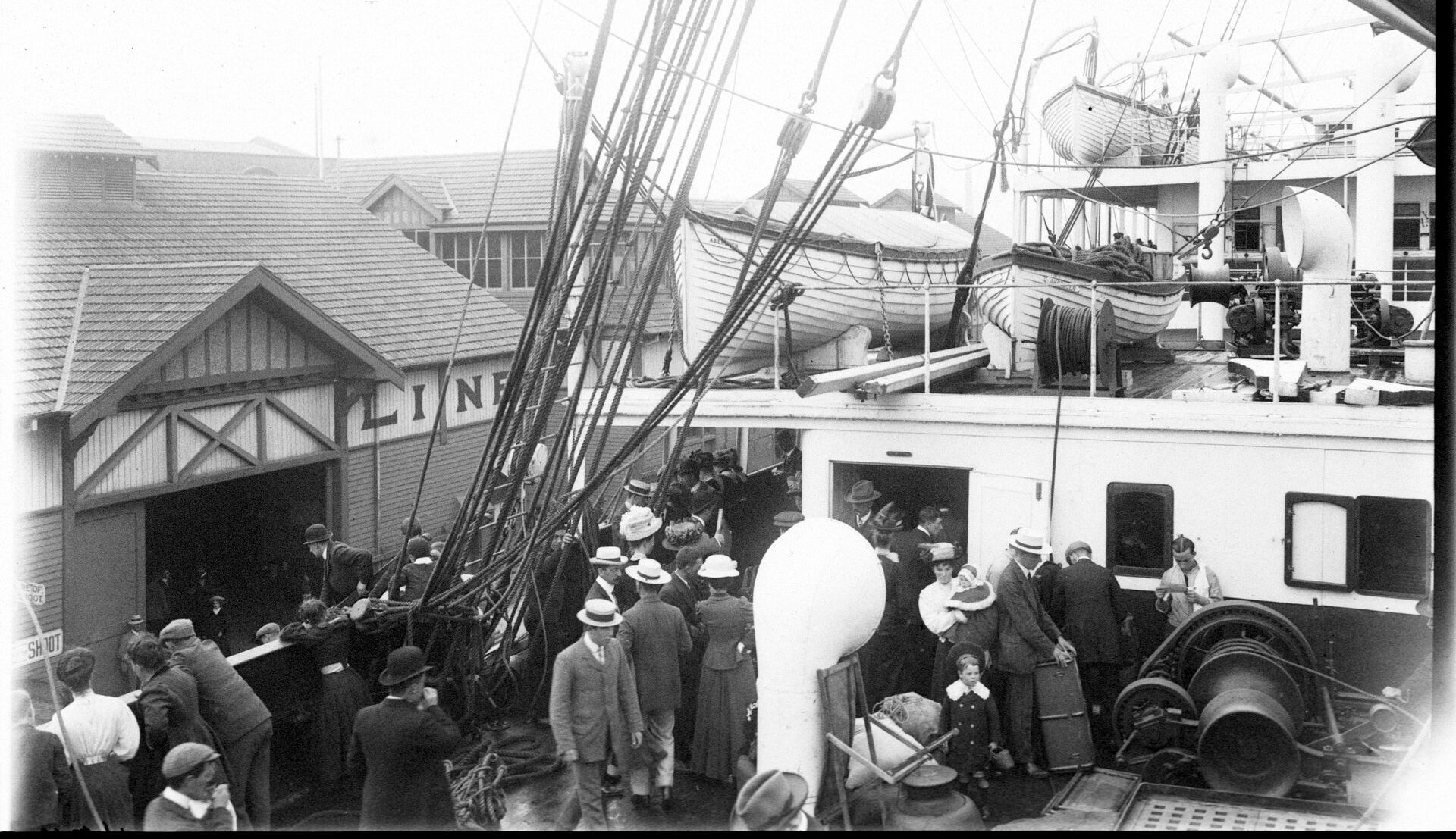 People crowd onto the deck of a ship