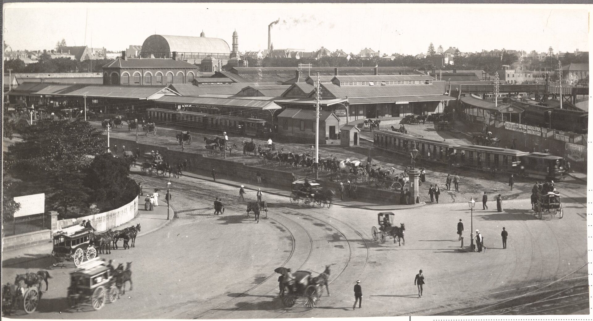 Sydney traffic scene 1900 with horses and carts, pedestrians and the Sydney Railway Station in the background