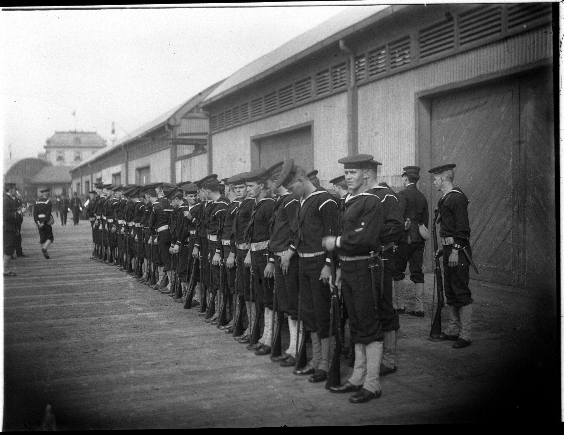 Sailors stand at attention on a wharf