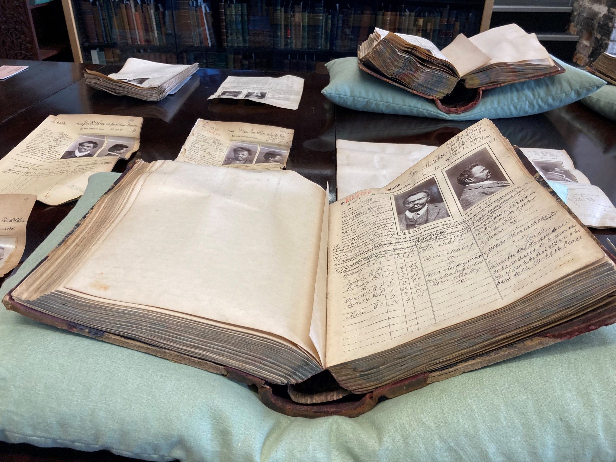 A large book open at a prisoner mugshot and description sits on a pillow