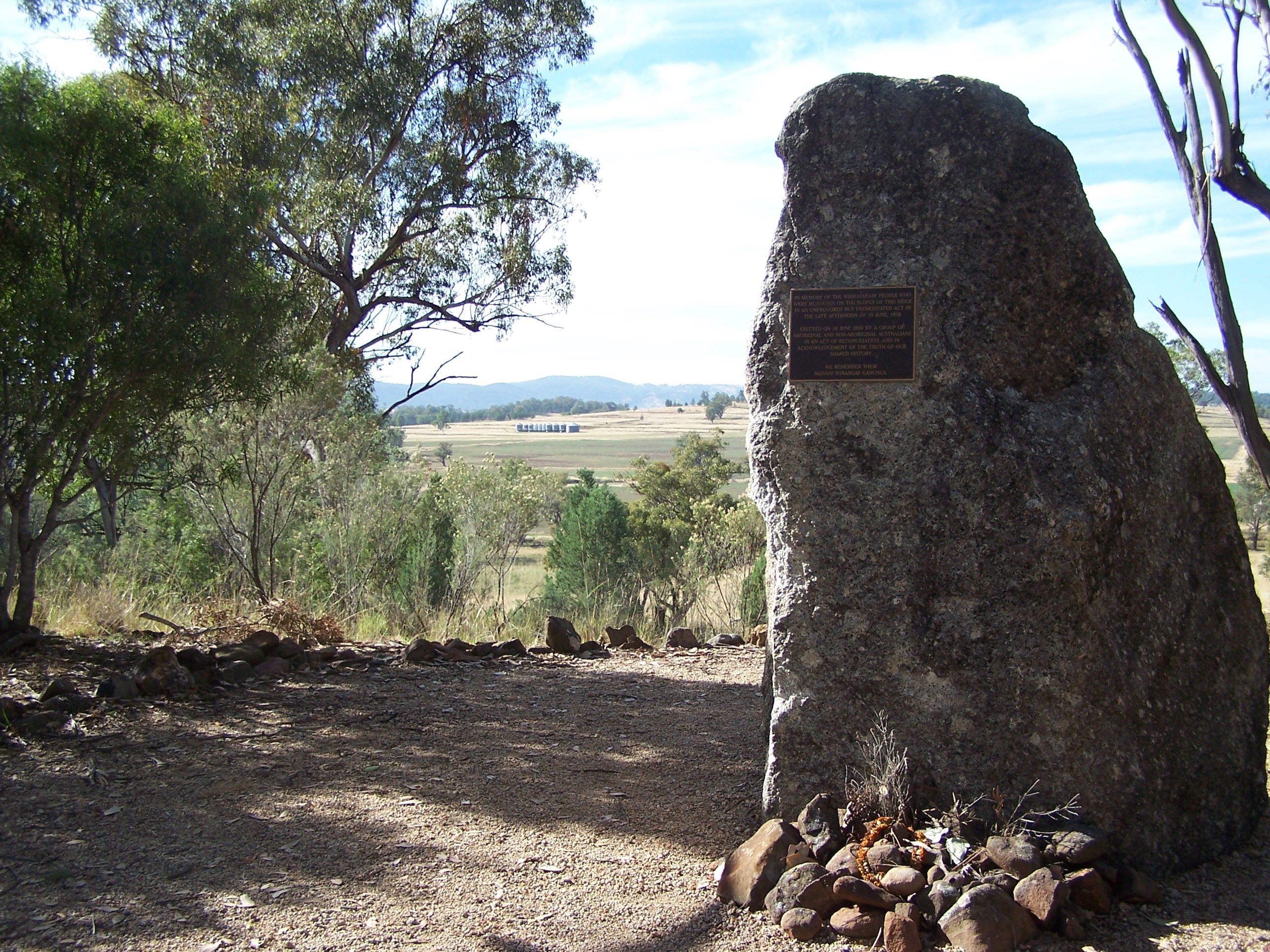 Stone monument with plaque with distant view behind.