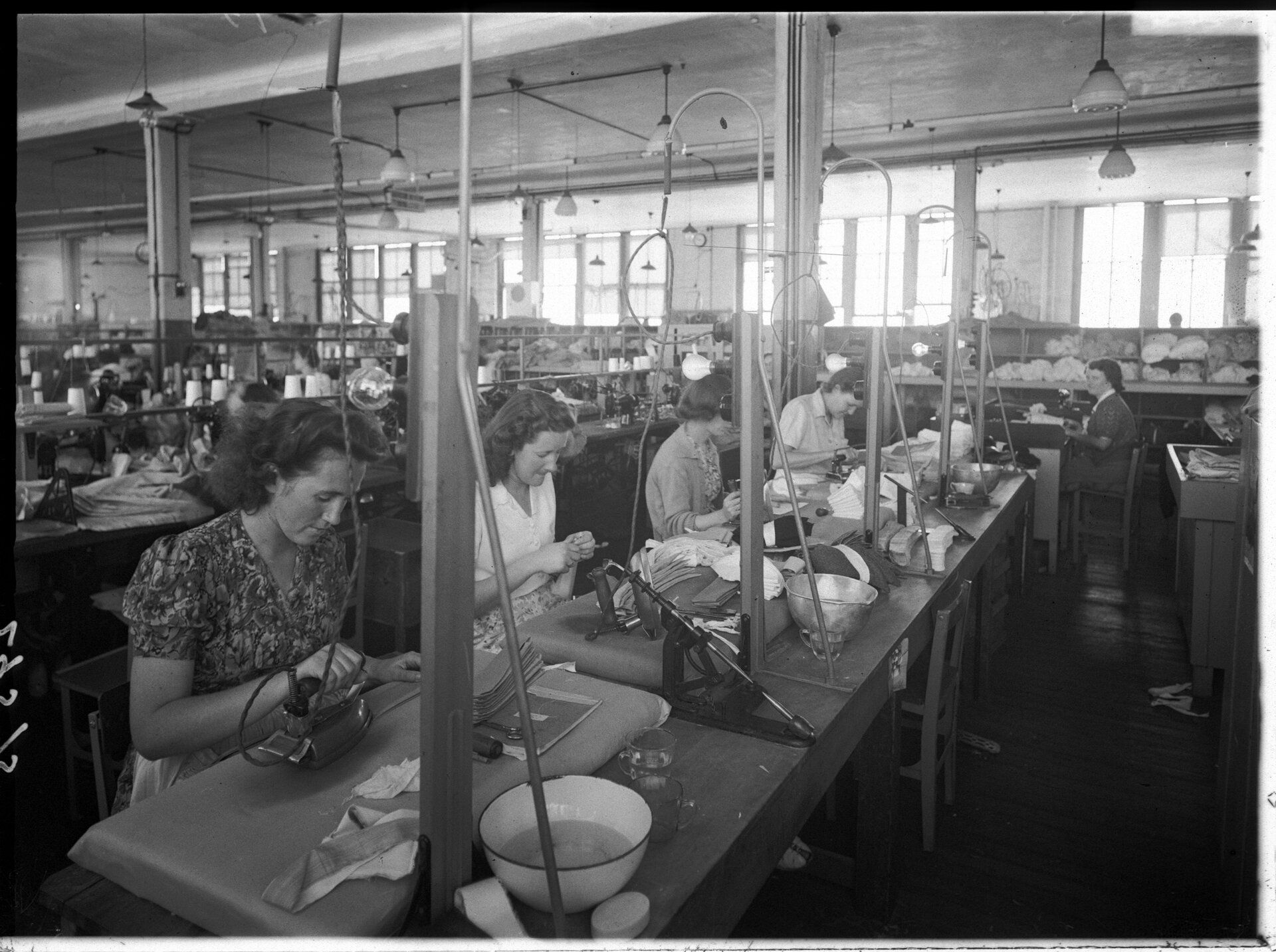 Fabric workshop - female employees working on fabrics at long work benches