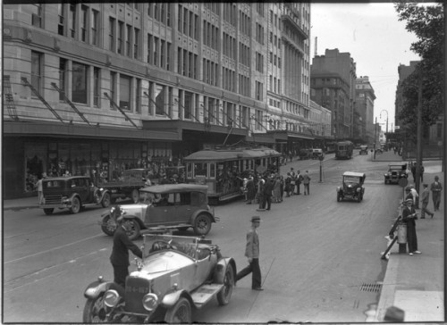Elizabeth Street, Sydney in 1931 showing cars, shops and trams