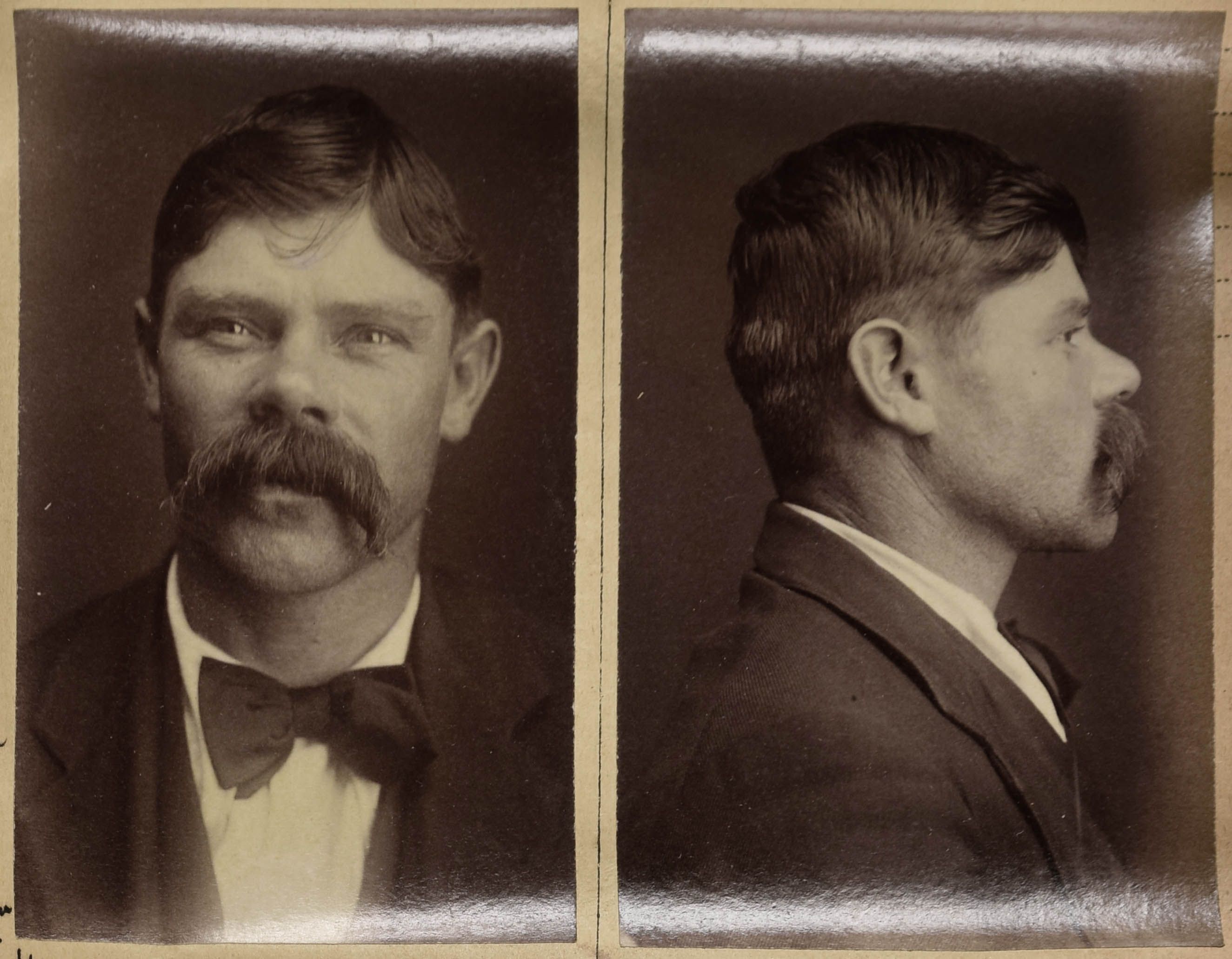 Black and white mugshots - one front-on, one side-on - of a man with a large moustache