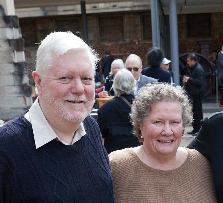 A man and woman smile to camera