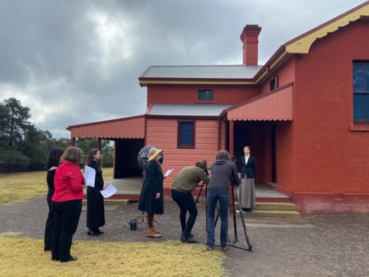 A film crew set up outside a heritage building