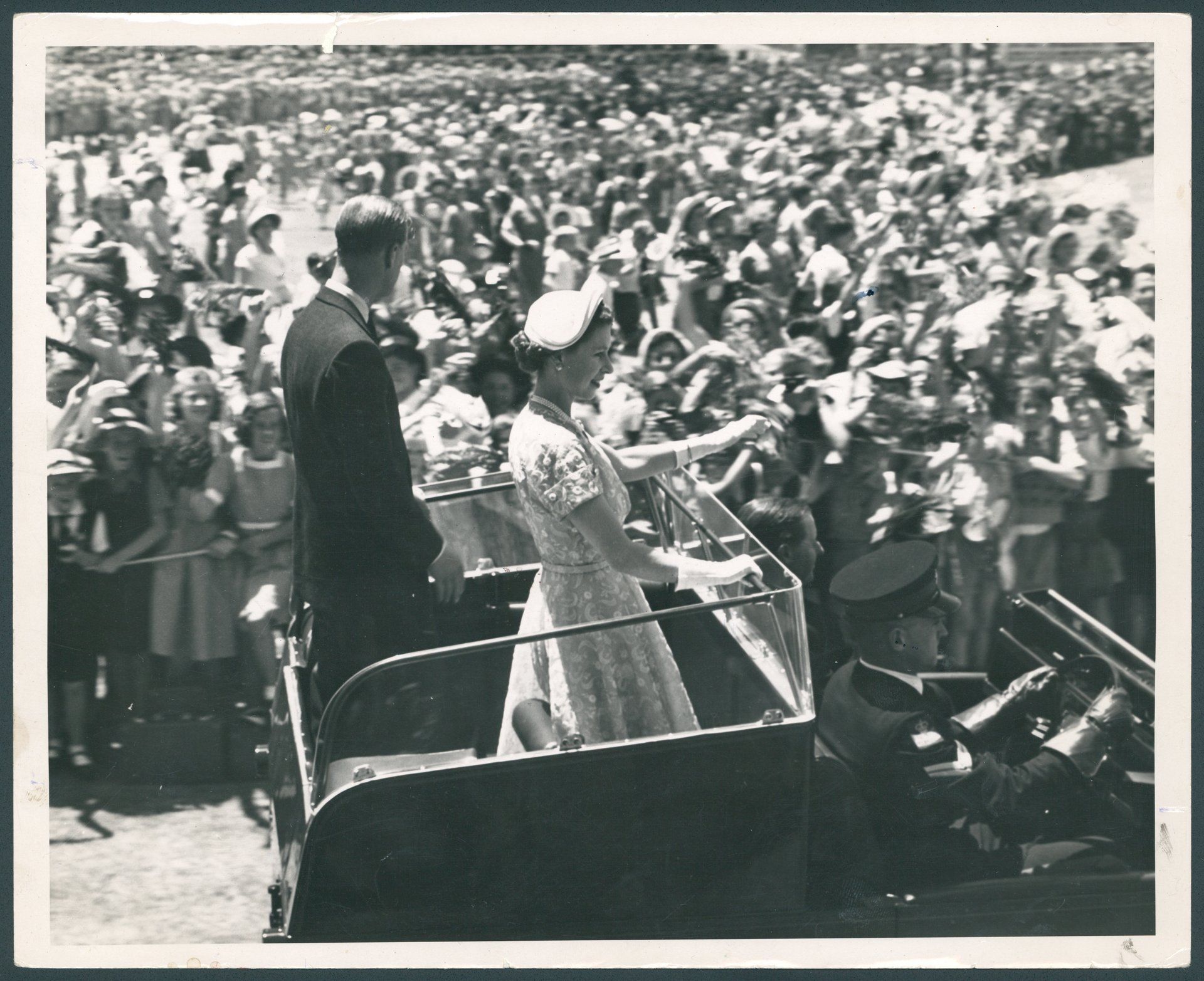 Queen Elizabeth II and the Duke of Edinburgh wave to children at the schools' gathering at Sydney Cricket Ground 1954