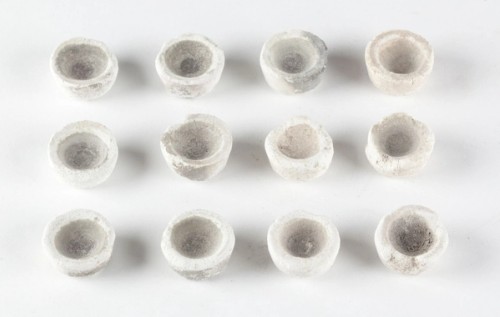 A group of 12 think rimmed cups on a white background