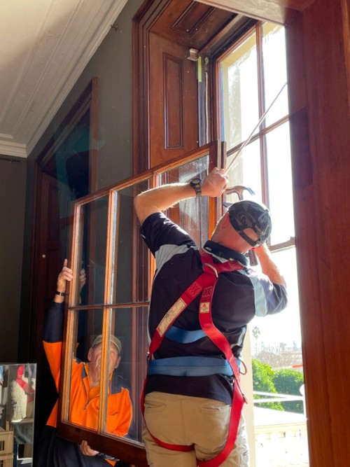 Conservation joiner nailing sash cords onto bottom sash in preparation for installation