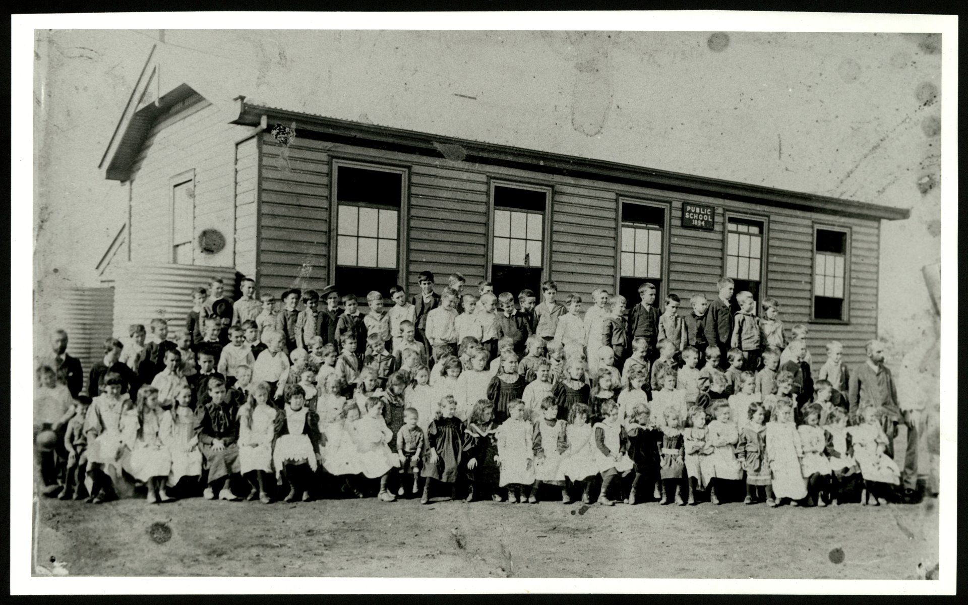 Students pose for photo in front of school building