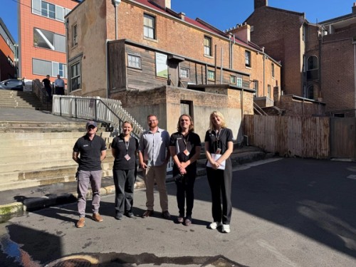 A group stands in front of a row of terrace houses