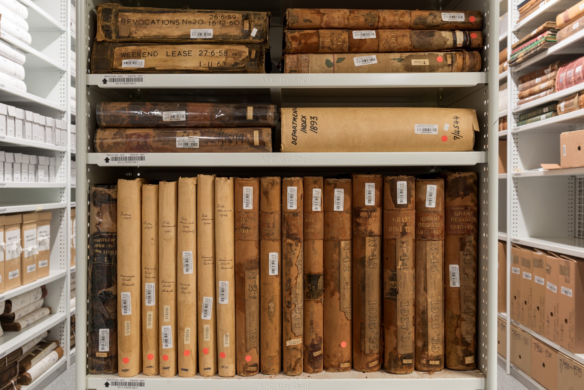 Old books both upright and laying flat on shelving