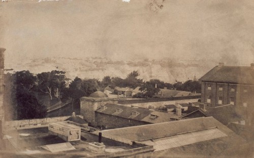 Old black and white image of a group of buildings.