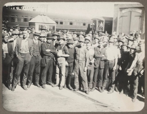 A large group of men stand in front of a train carriage at the Eveleigh Workshops in 1917