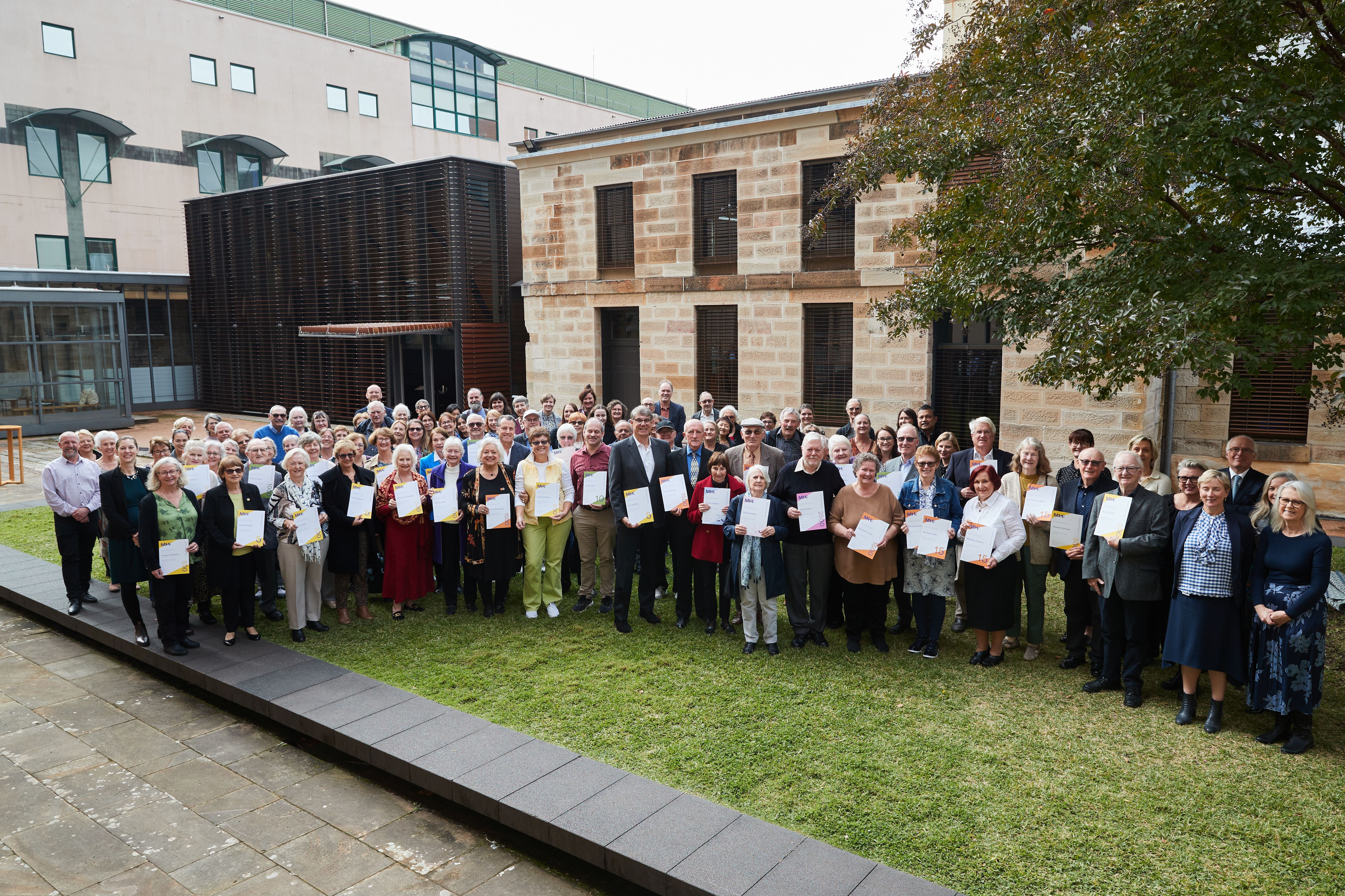 A large group photo showing the volunteer team gathered at The Mint for their annual Volunteers’ Morning Tea.