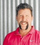 Man in a red shirt, smiling at the camera