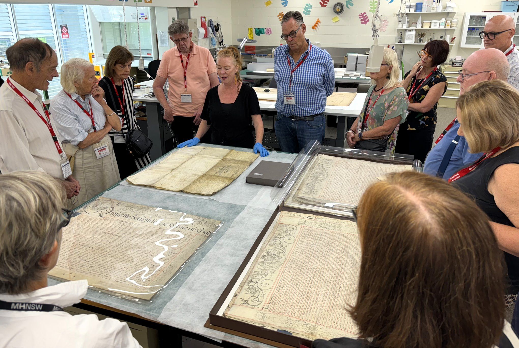 A group crowds around a display of archival documents