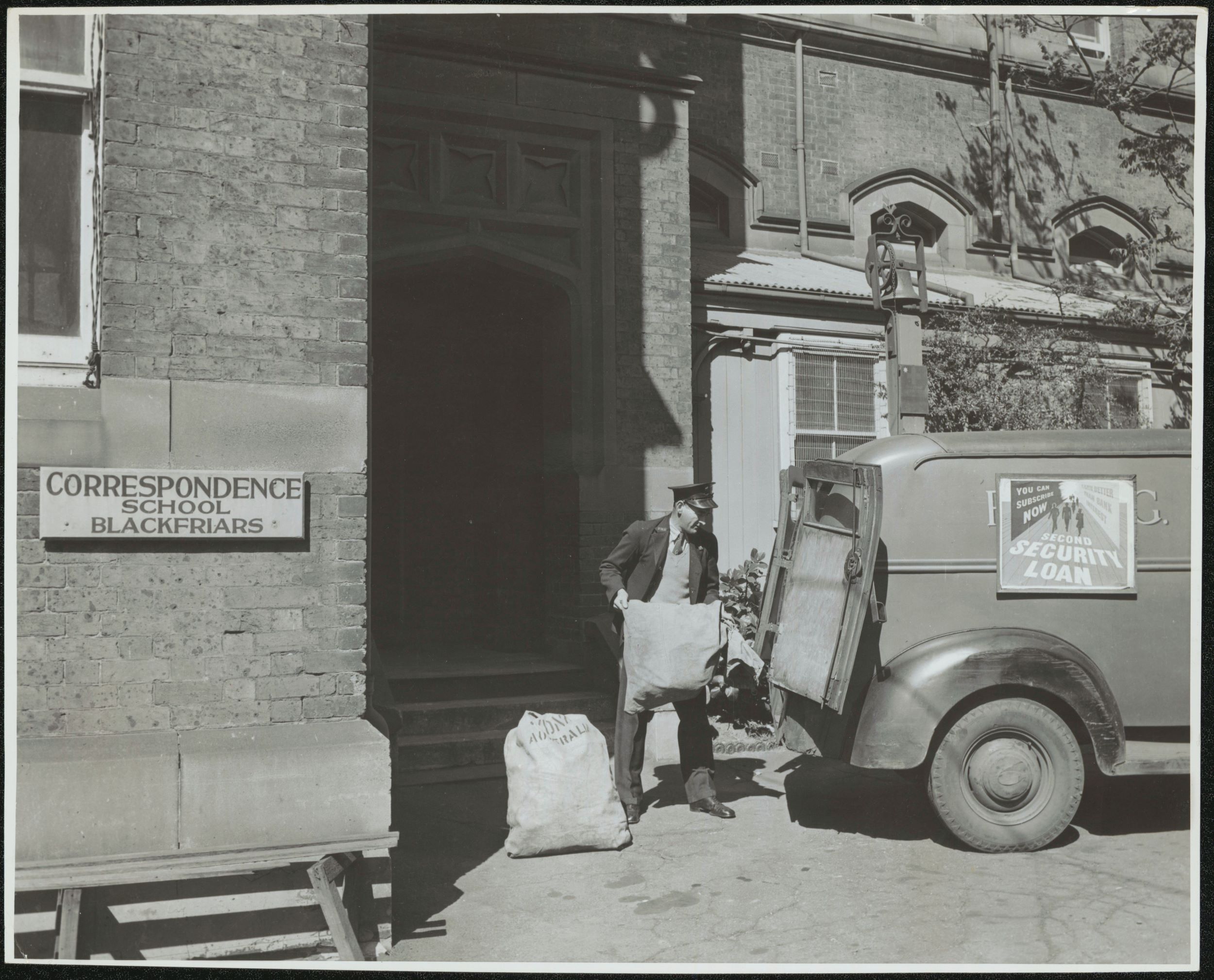 Mailman packing the delivery van with sacks of mail.