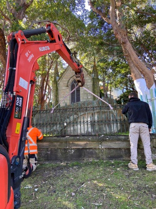 Crane lifting up a section of fence