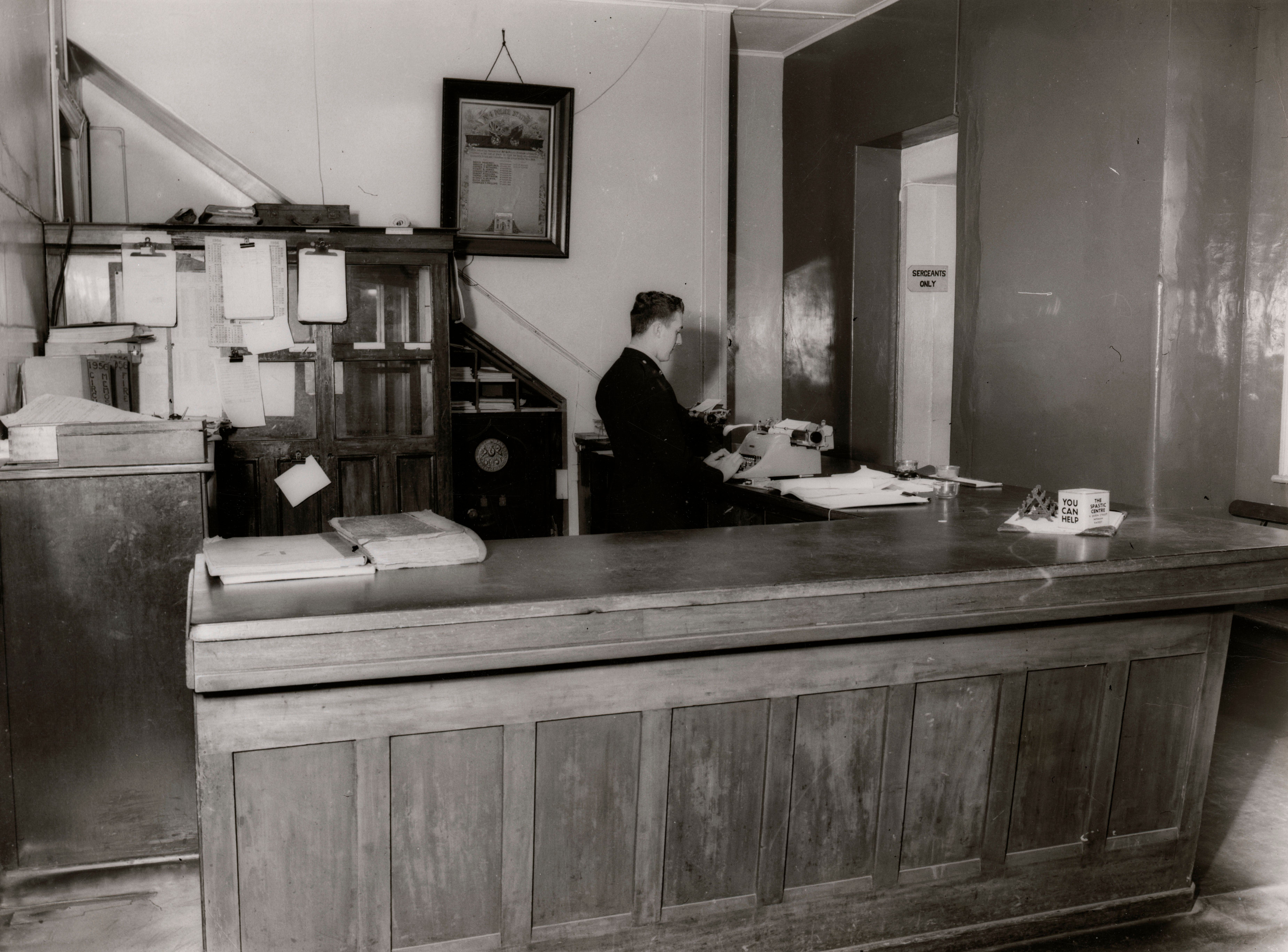 Black and white image of a man at a typewriter