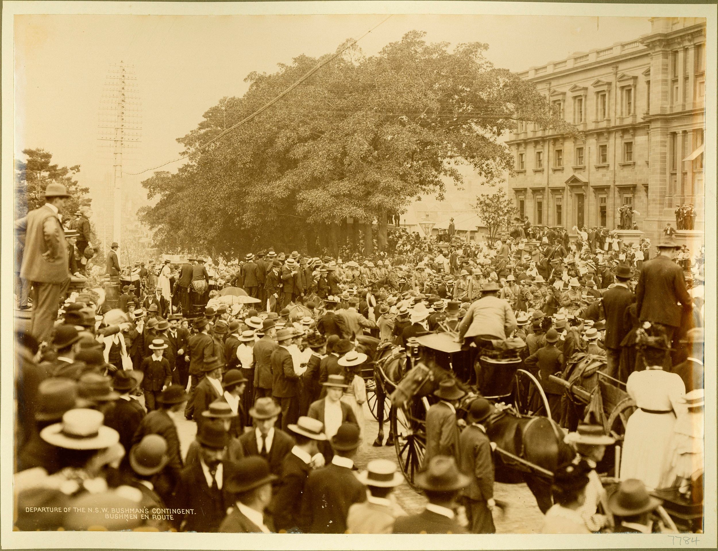 Large crowds watch a military procession