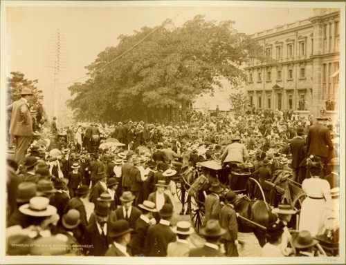 Large crowds watch a military procession